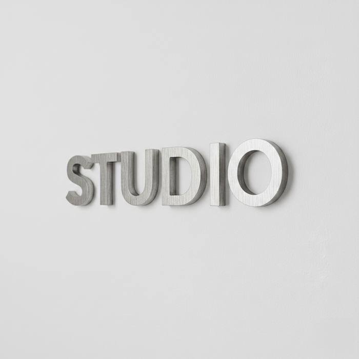 Angled view of raised aluminum letters spelling Studio.