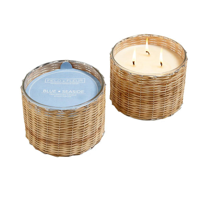 Hillhouse Naturals 21 oz 3-wick candle in a handwoven rattan basket with a blue Seaside label and lit wax.