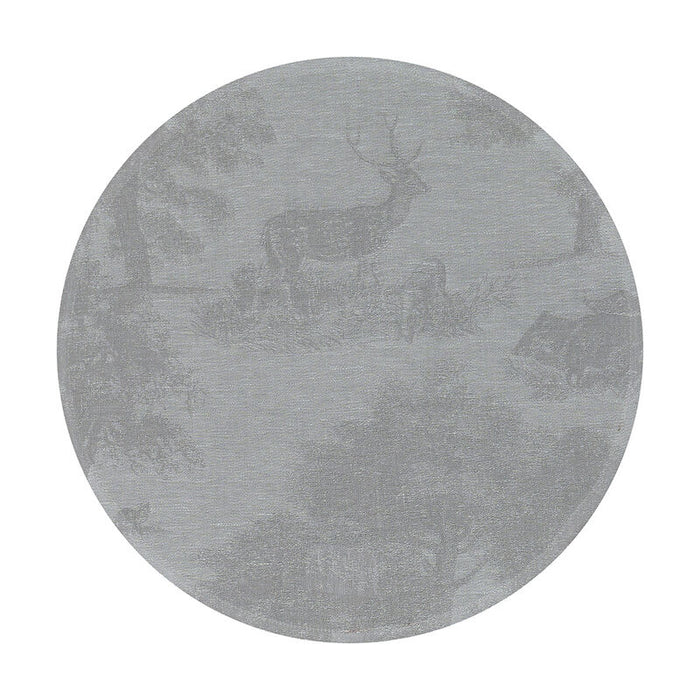 Round grey linen placemat featuring an intricate toile de Jouy forest wildlife motif with deer and lush vegetation.