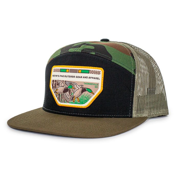Seven-panel trucker cap with camo print, olive flat bill, mesh back, and a Kevin's Mallards patch on the black front.