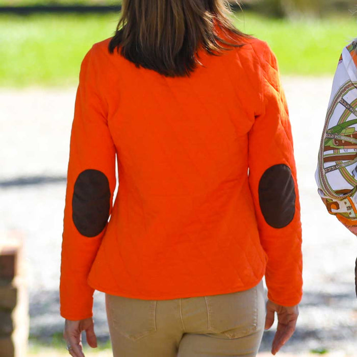 Bright orange quilted pullover with dark brown elbow patches and a textured jacquard finish worn outdoors.