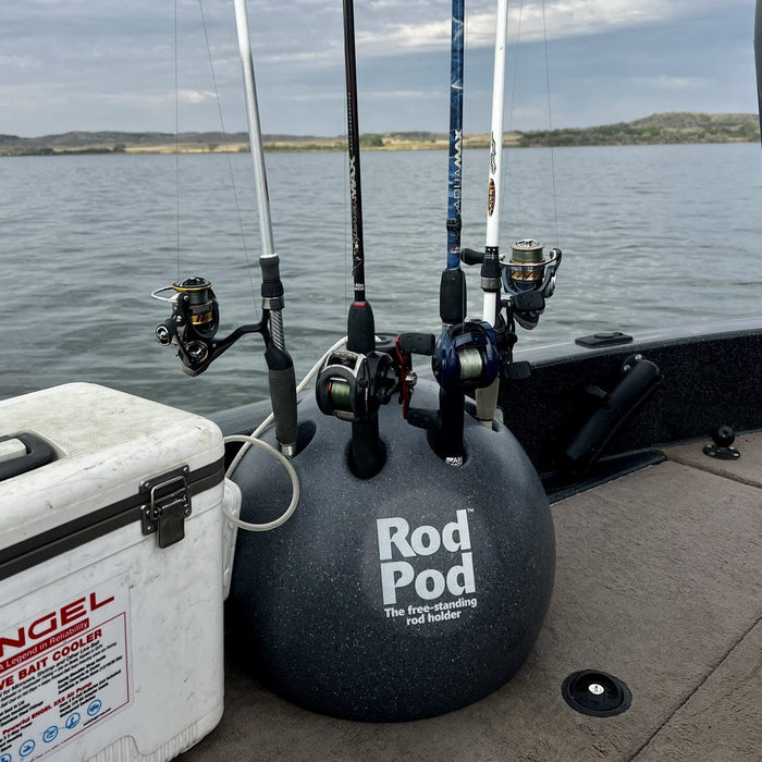 Grey roto-molded Rod Pod fishing rod holder holding four rods on a boat deck next to a white cooler.