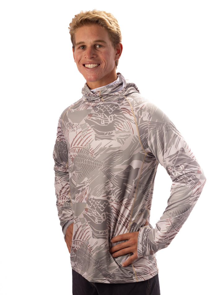 Male model wearing the Waihana Sandy Sun Shirt in a grey and earth-tone fishbone camo print with a built-in hood, photographed against a white studio background.