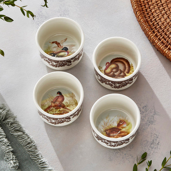 Set of four Spode Woodland porcelain ramekins featuring brown floral borders and detailed interior animal illustrations.