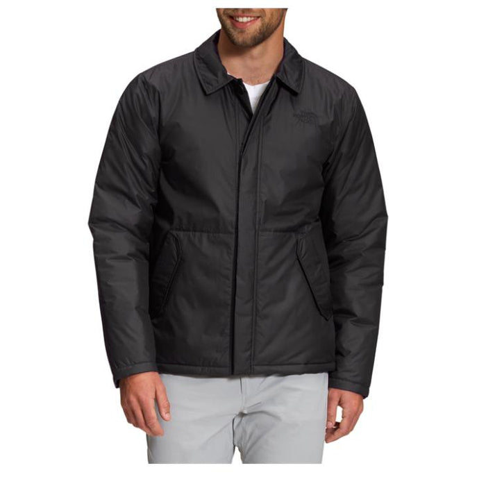 Man wearing a black The North Face Auburn insulated jacket with a classic collar and front zip closure.