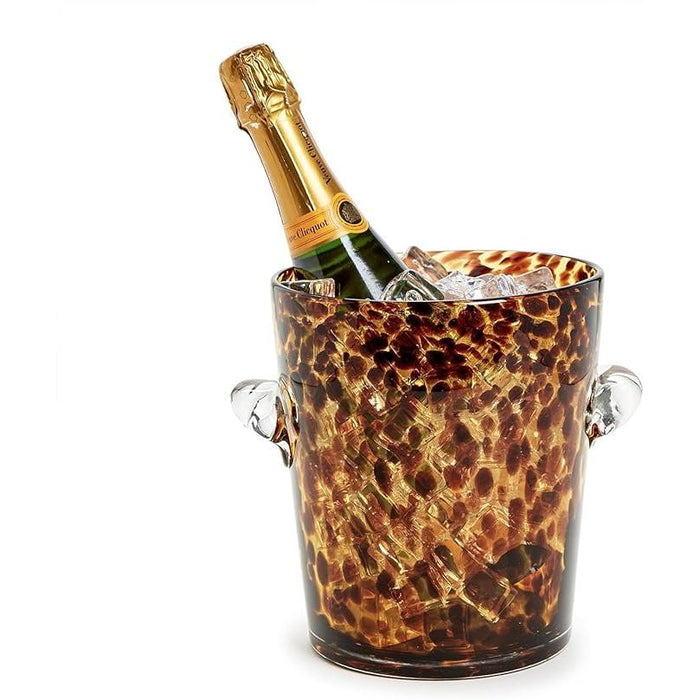 Glass ice bucket with a brown tortoise print, clear side handles, and a champagne bottle chilling in ice.