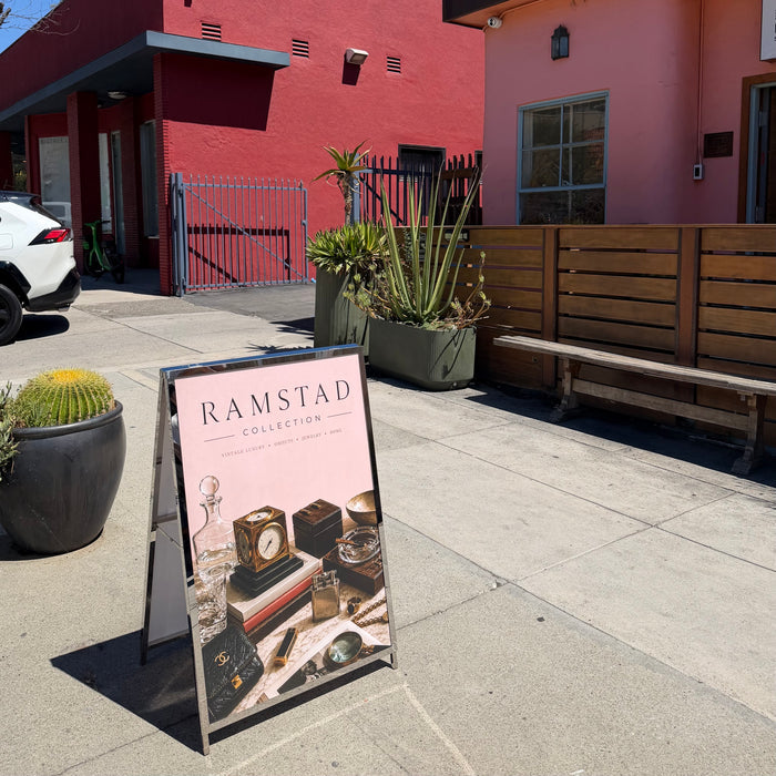 Ramstad poster displayed in a metal A-frame sign on a sidewalk.