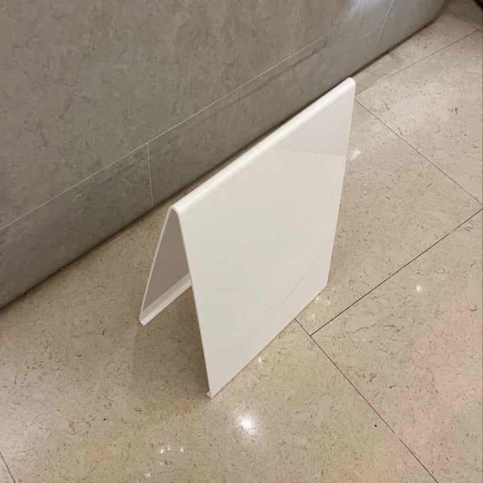 Top view of a white acrylic A-frame sign showing the rounded fold.