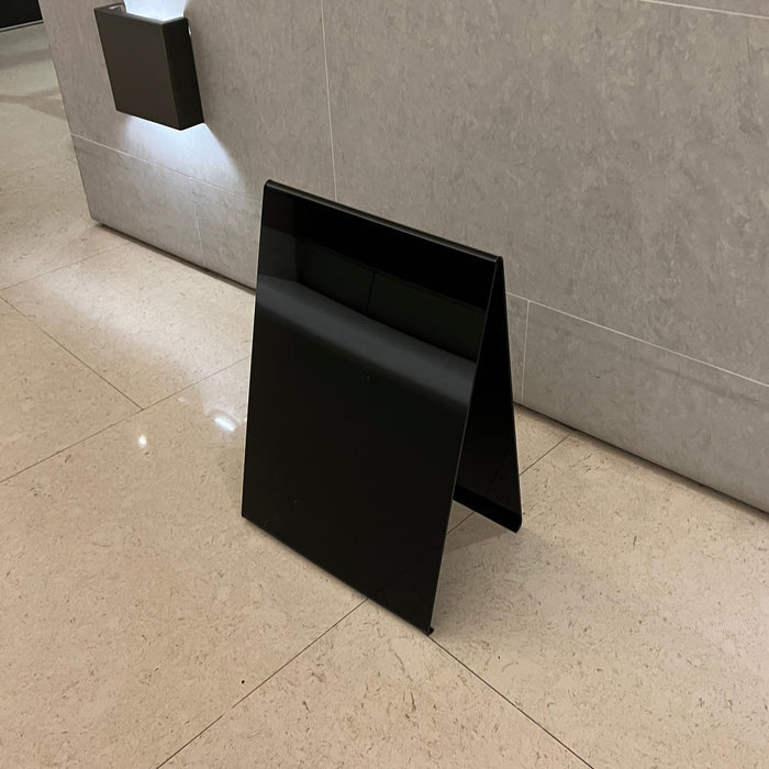 Right angled view of a blank black opaque acrylic A-frame sign.