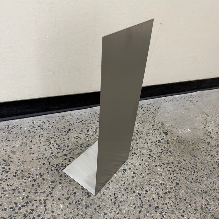 Side view of a slanted stainless steel floor sign showing its flat base.