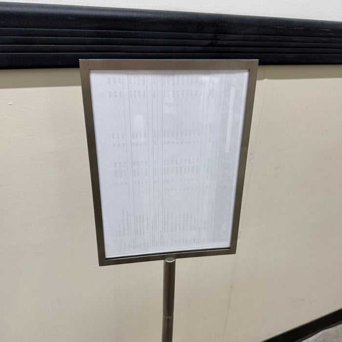Close-up of the rectangular menu frame on a stainless steel pole sign.