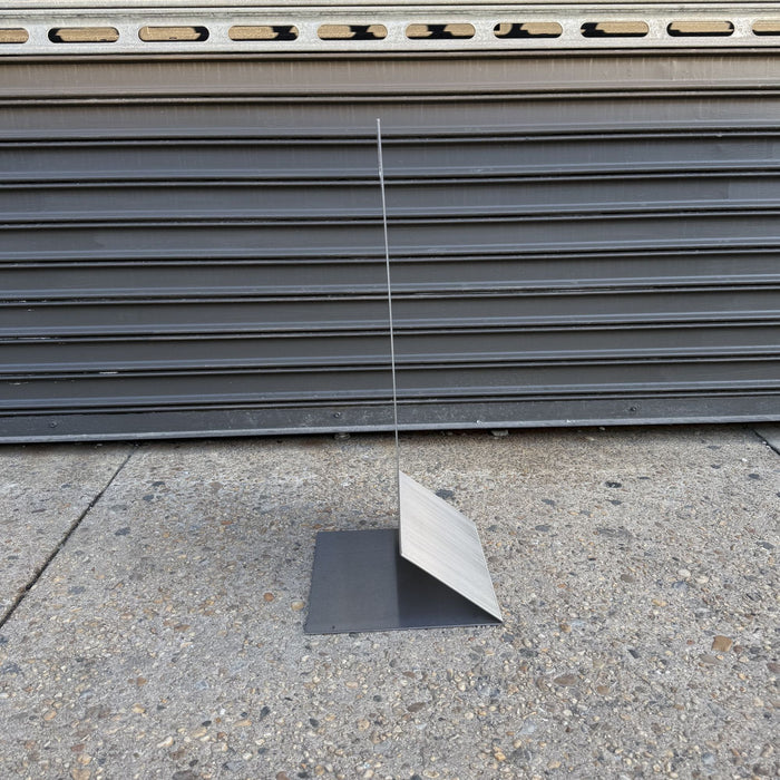 Side profile of a stainless steel floor sign showing its thin panel and folded base.
