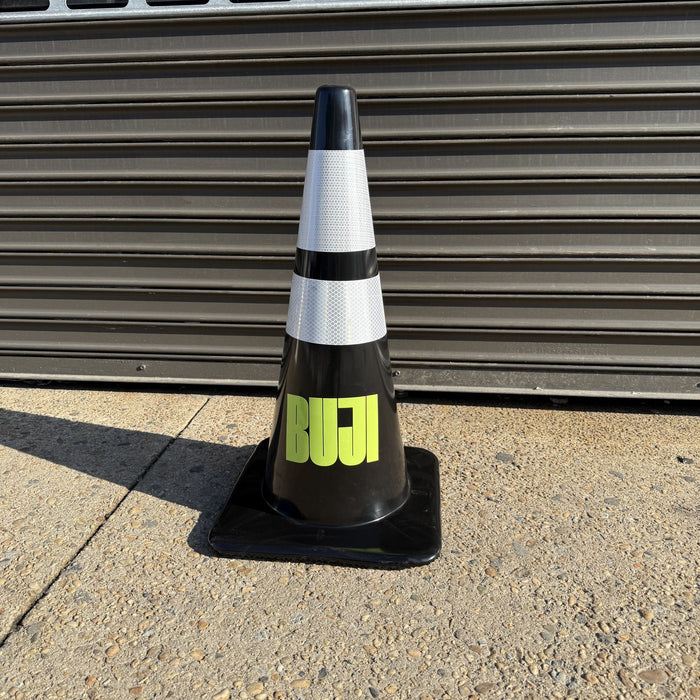 Black traffic cone with bright green lettering beneath two reflective bands.