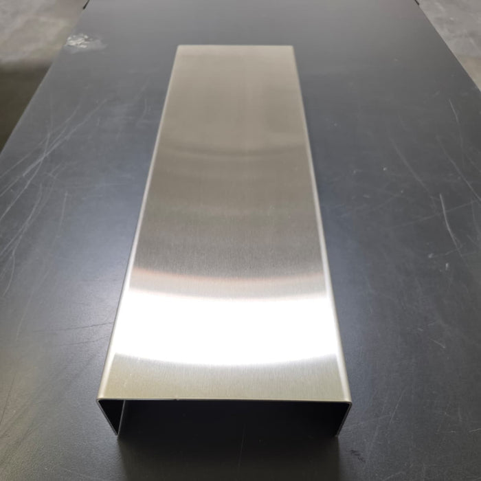 End view of a long stainless steel display riser showing the open space beneath.