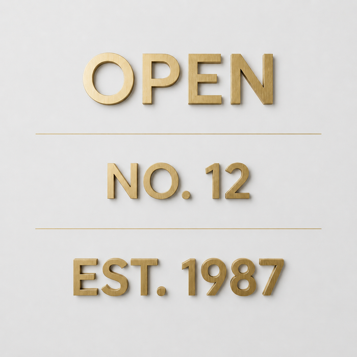 Dimensional brass lettering samples reading Open, No. 12, and Est. 1987.