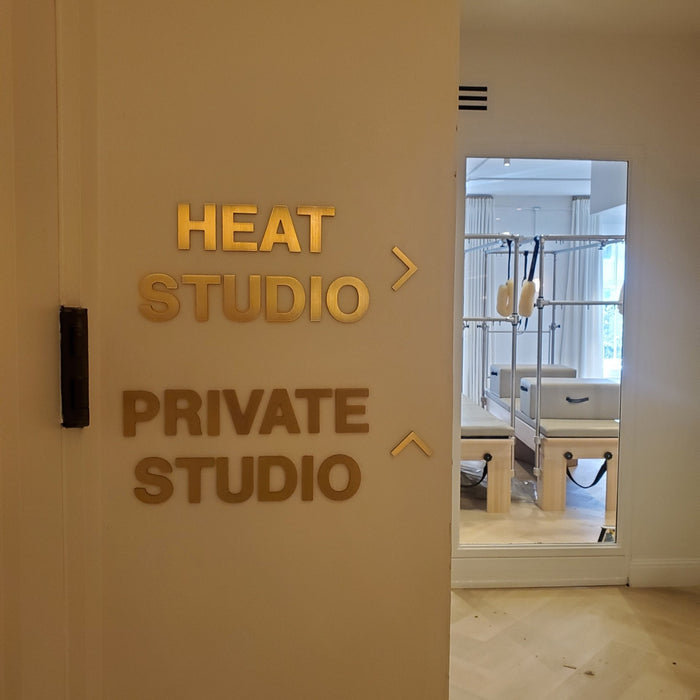 Brass Heat Studio and Private Studio directional lettering beside a doorway.