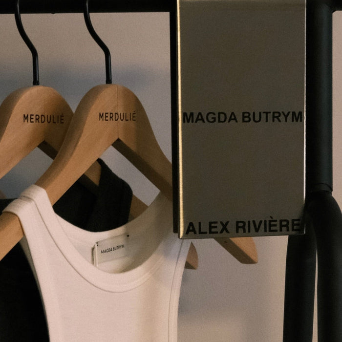 Metal clothing rack sign clip with Magda Butrym and Alex Rivière lettering.