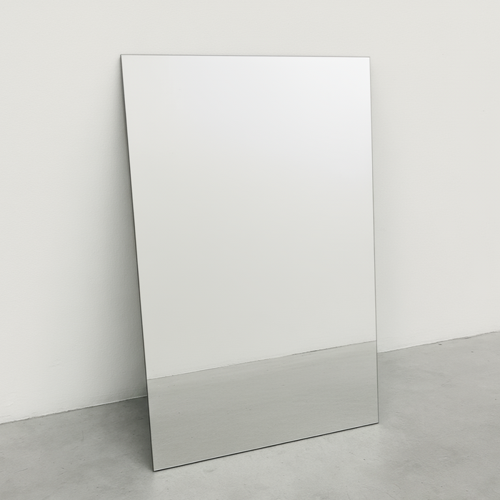 Blank mirrored stainless steel rectangular panel leaning against a wall.