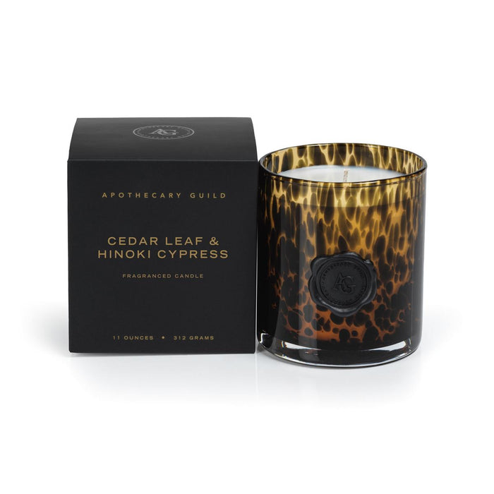 Tortoiseshell glass candle with black wax seal next to a black Apothecary Guild gift box.