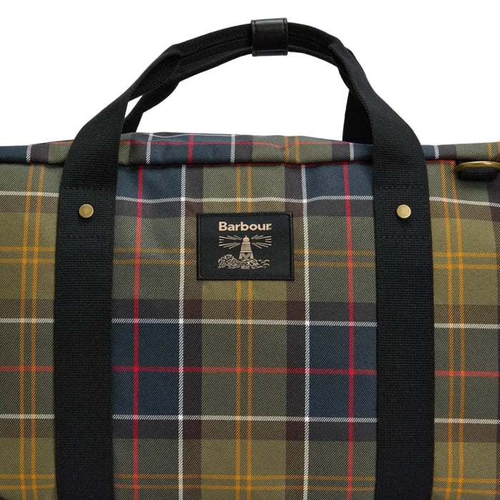 Barbour Torridon holdall in classic tartan fabric with black webbing handles and a branded lighthouse logo badge.
