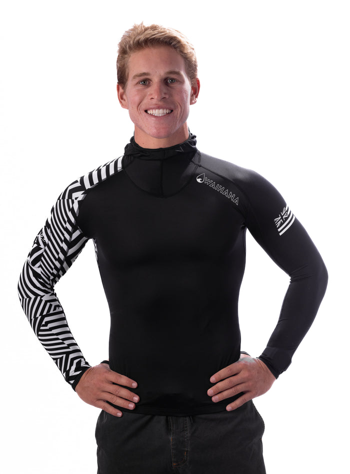 Male model wearing the Waihana Black Carvico Hooded Surf Rashguard featuring a black body with bold geometric black-and-white patterned sleeves and a built-in hood, photographed against a white studio background.