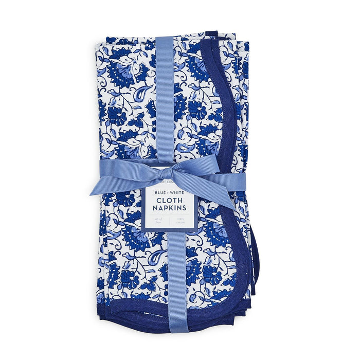 Set of four blue and white floral cotton napkins with scalloped edges, tied with a blue ribbon.