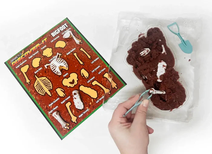 Discover It - Bigfoot Dig kit showing dissection tools and fossil-like bones in gelatin material for kids.