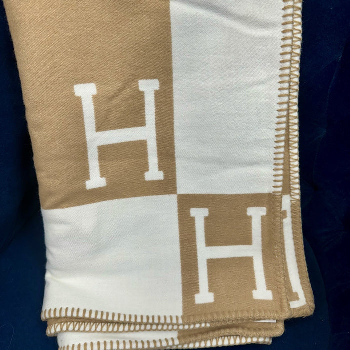 Soft tan and white equestrian-style blanket with H-pattern, featuring a luxurious acrylic-cashmere blend and stitched edges.