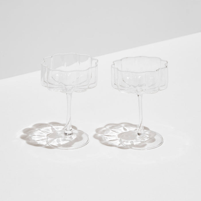Set of two hand-blown clear borosilicate glass coupe glasses with elegant rippled edges and elongated stems.