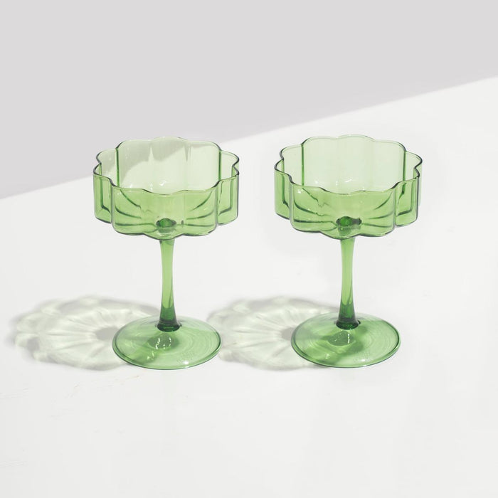 Set of two hand-blown green borosilicate glass coupe glasses with elegant elongated stems and signature rippled edges.