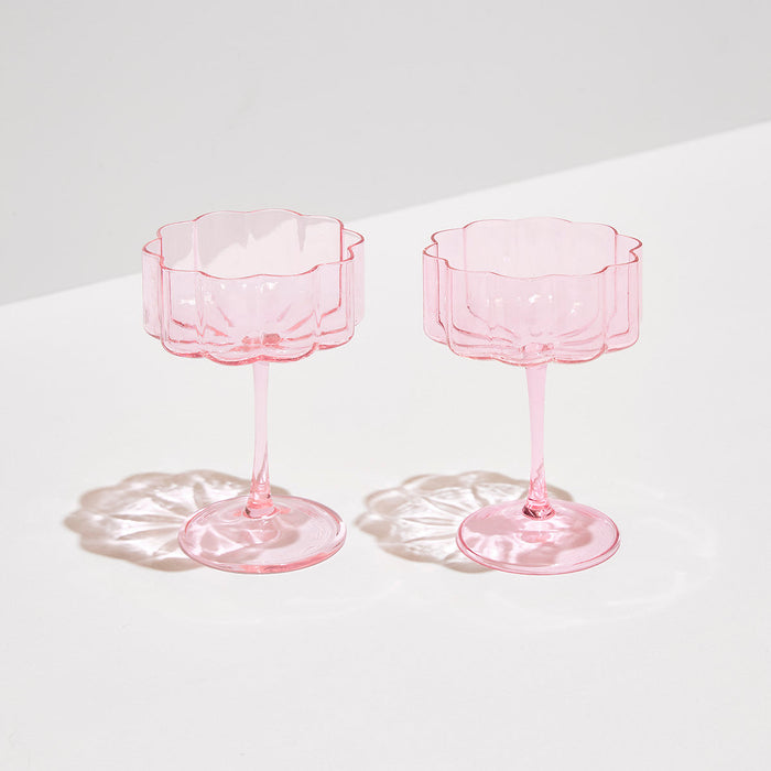 Set of two hand-blown pink borosilicate glass coupe glasses with elegant elongated stems and signature rippled edges.