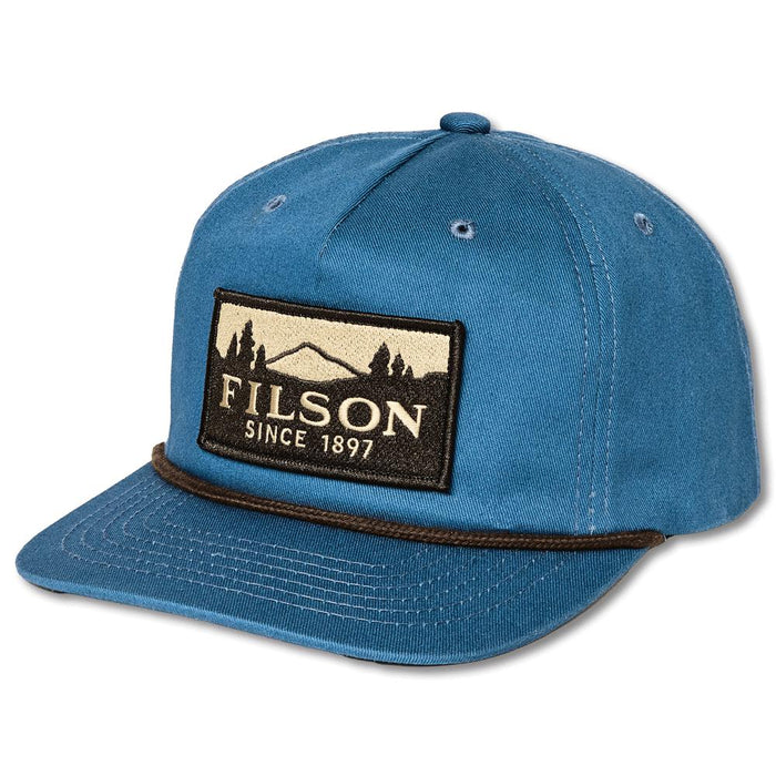 Blue Filson 5-panel trucker cap in cotton ripstop with a flat brim, brown rope trim, and vintage mountain logo patch.