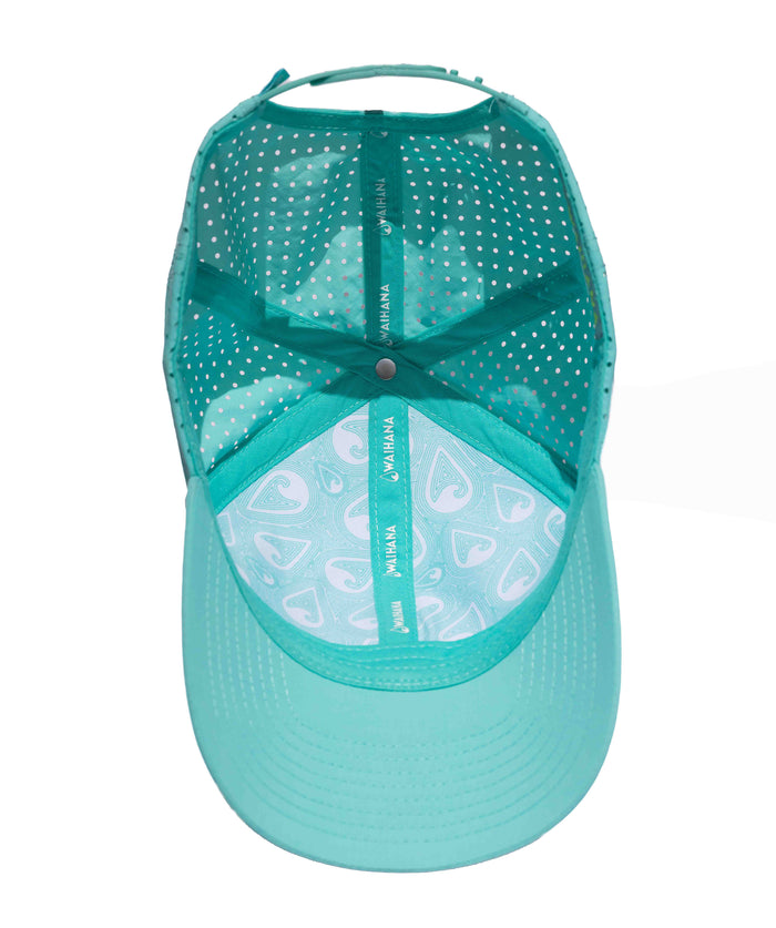 Inside view of the teal Waihana Hula Diver Hydro Hat revealing polka-dot interior lining, branded Waihana taping, and a fish-hook patterned underside on the brim.