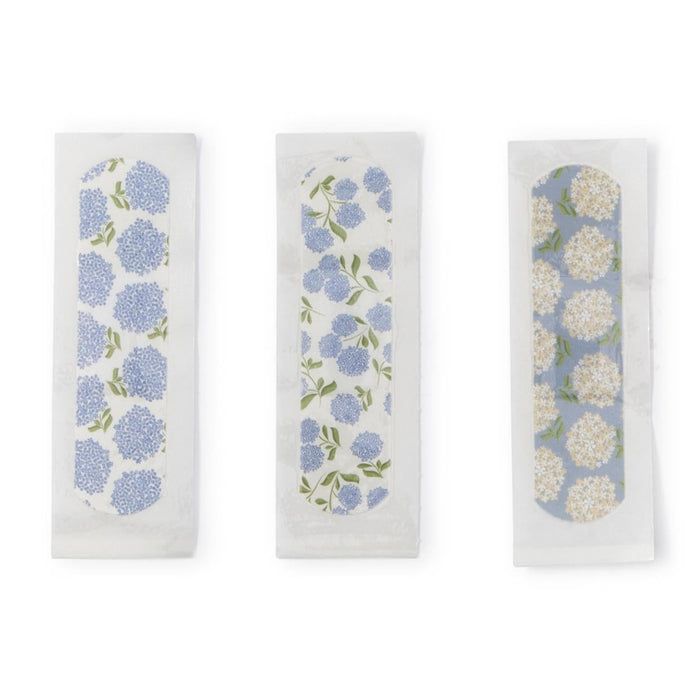 Three plastic adhesive bandages featuring blue, white, and green hydrangea floral patterns on a white background.