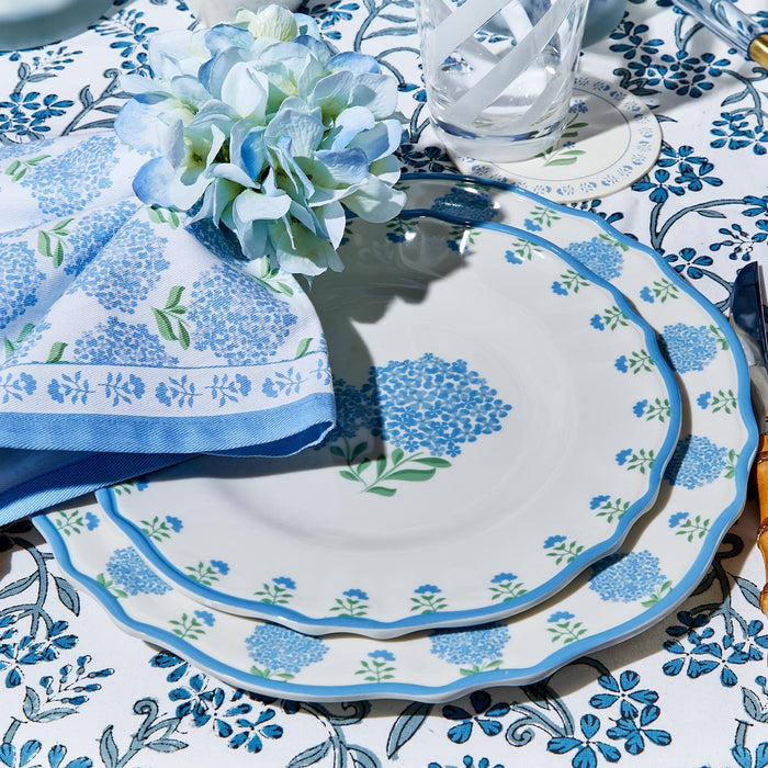 Set of four blue and white cotton hydrangea napkins featuring a floral print, displayed on a matching table setting.