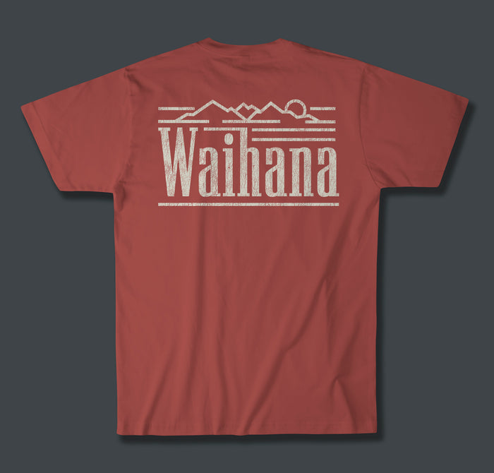 Back of a burnt earth red Waihana Island Original Premium Pima T-Shirt featuring a distressed cream Waihana wordmark with mountain and rising sun graphic printed across the upper back.