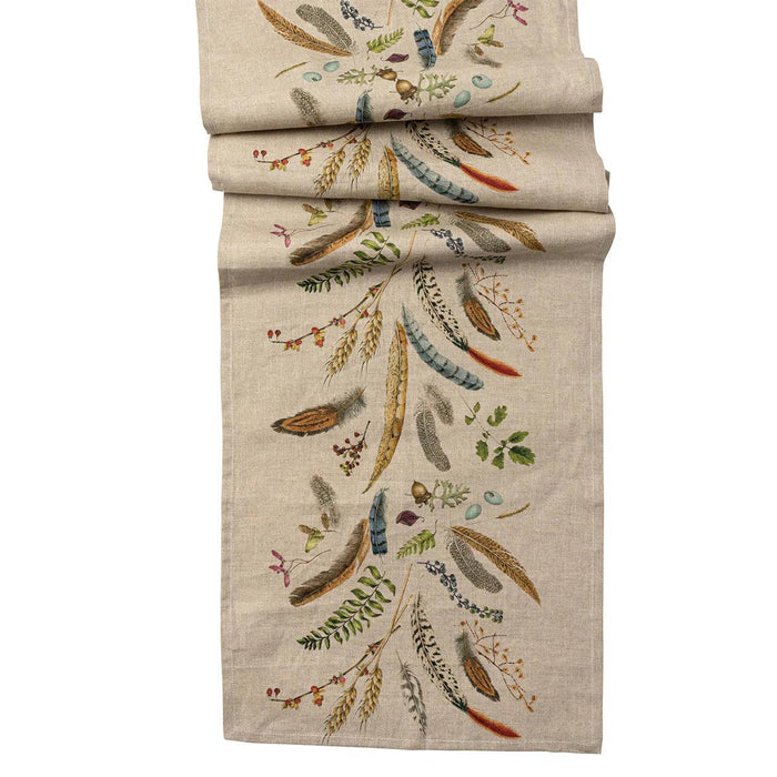 18x90-inch beige linen table runner featuring a whimsical forest-inspired print of colorful feathers, flora, and fauna.