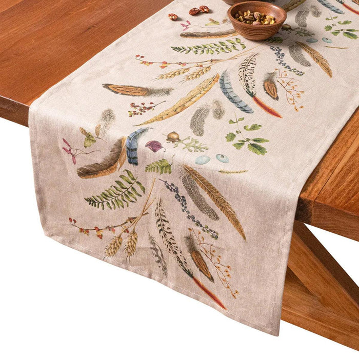 18x90-inch linen table runner featuring whimsical forest flora and feather motifs on a natural beige background.