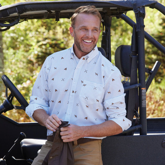 Man wearing a white long-sleeve performance shirt with a brown pointer dog tattersall print and button-down collar.