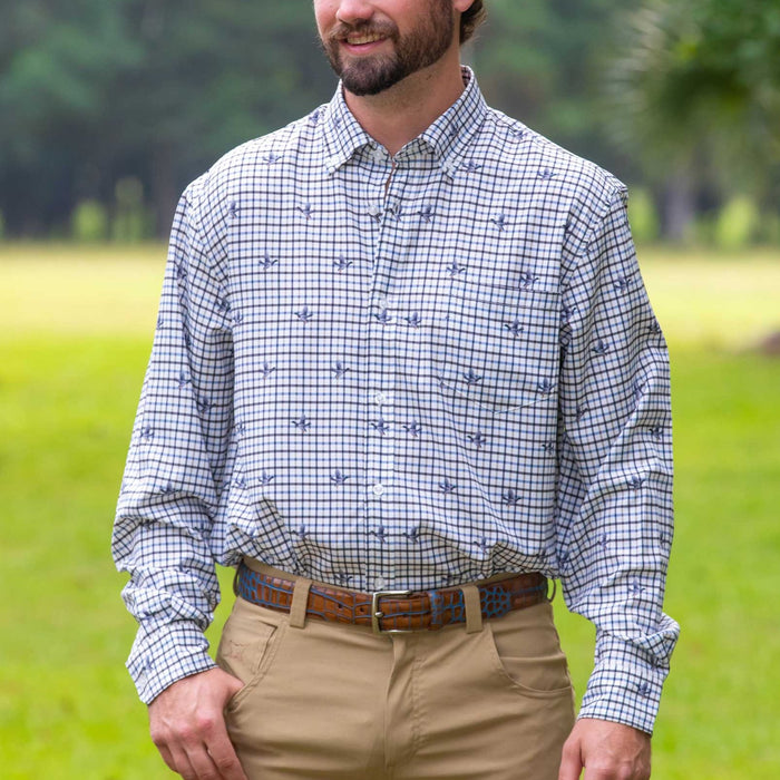 Man wearing a long-sleeve, moisture-wicking tattersall performance shirt with a blue flying duck print pattern.