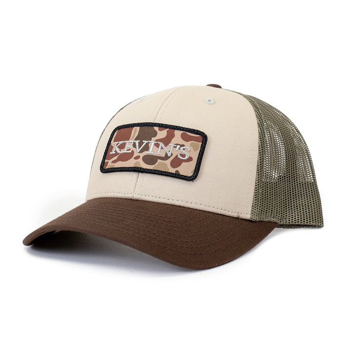 Kevin's low-profile trucker cap featuring a tri-color camo patch, tan front panels, brown brim, and olive mesh back.