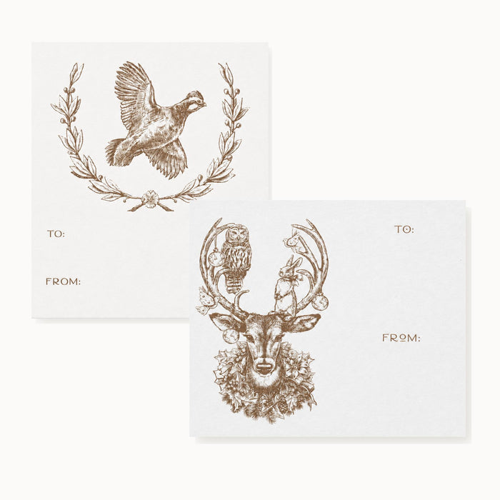 Two white gift stickers featuring brown ink illustrations of a quail wreath and a deer with forest animals.