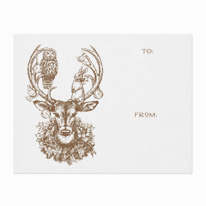 White paper gift sticker featuring a brown ink deer illustration with woodland animals, ornaments, and To/From text fields.