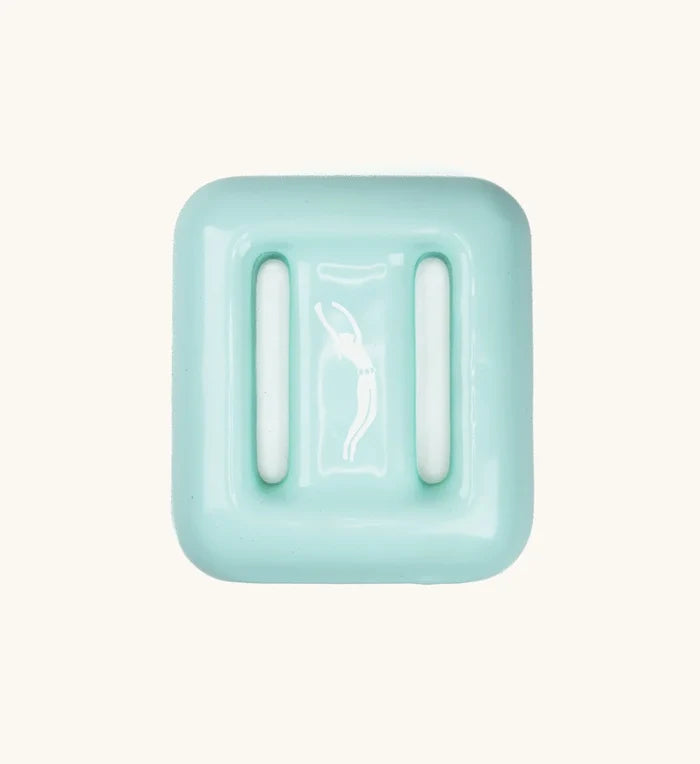 Mint green Lanikai dive weight by Bright Buoy Diving, showing molded ribbed surface and embossed freediver silhouette logo, photographed from above on a light background.
