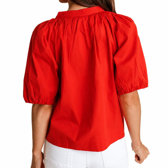 Back view of a vibrant red cotton poplin Henley top featuring draped puff sleeves with elastic cuffs.