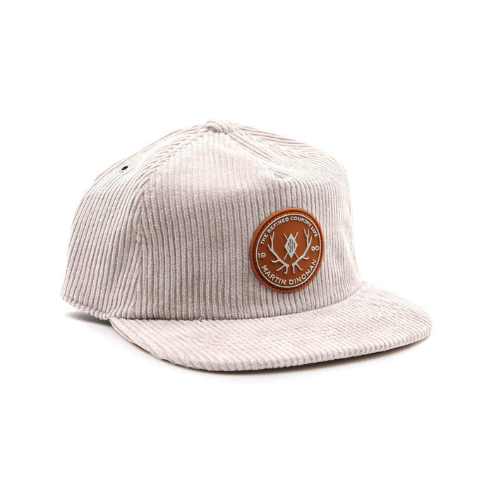 Light beige six-wale cotton corduroy cap with a brown leather logo patch featuring an antler design.