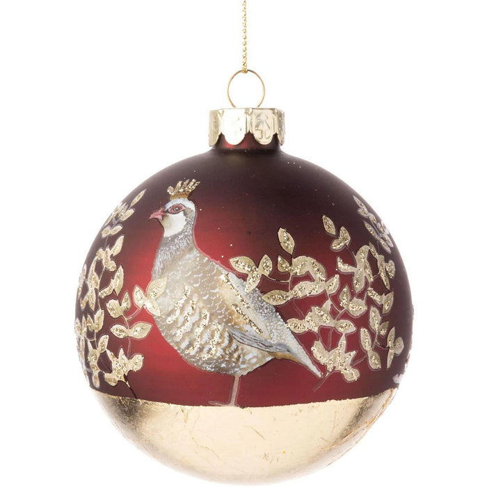 Matte red glass Christmas ornament featuring a partridge and glittered gold leaf design, 3-inch round holiday decoration.