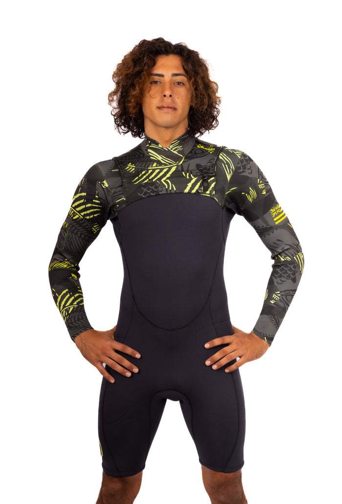 Male model wearing the Waihana Men's Lime Fishbone Long Sleeve Spring Suit, a black neoprene shorty wetsuit with vibrant lime yellow and dark grey patterned sleeves and chest panel, photographed front-on against a white studio background.