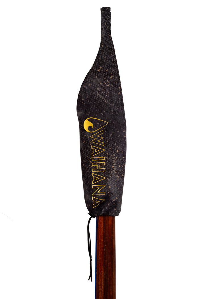 Waihana Neoprene Protective SpearSock in a dark snakeskin-style pattern covers the blade end of a wooden pole spear, with the gold Waihana logo and wordmark visible on the cover.