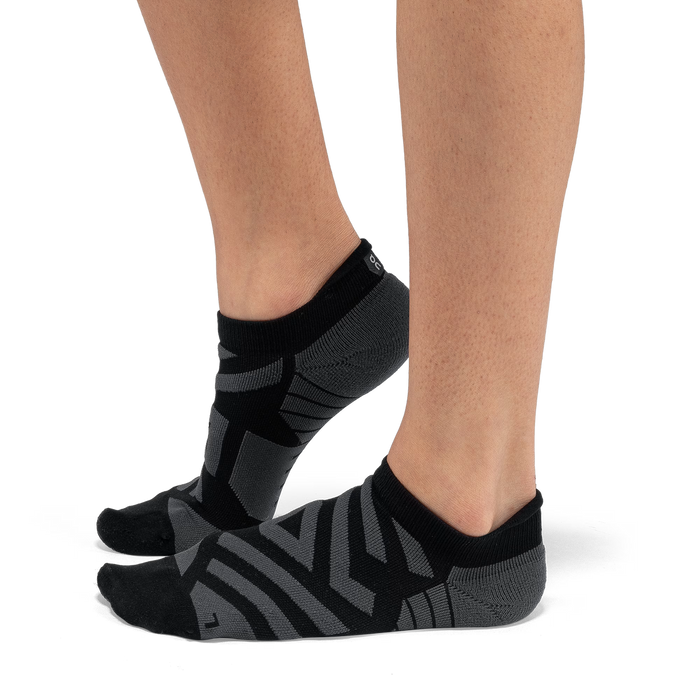 On Running women's low-cut performance running socks in black and grey with targeted arch support and mesh detailing.